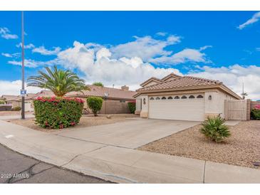 Charming single-Gathering home featuring a two-car garage, desert landscaping, and a tile roof at 1019 N Monterey St, Gilbert, AZ 85233