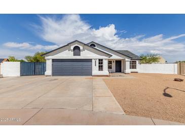 Charming single-story home with a two-car garage, gravel landscaping, and a well-maintained front yard at 10358 N 78Th Ave, Peoria, AZ 85345