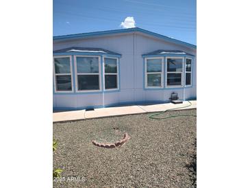 Charming home featuring large bay windows, light blue trim and low maintenance desert landscaping at 127 S 75Th Pl, Mesa, AZ 85208