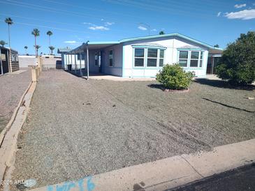 Charming single-story home with a gravel front yard and a covered porch and mature landscaping at 127 S 75Th Pl, Mesa, AZ 85208