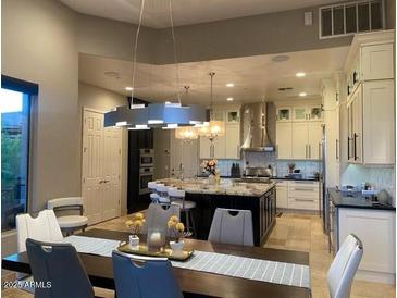 Bright kitchen with white cabinetry, stainless steel appliances, and a large center island with stone countertops at 15135 E Sundown Dr, Fountain Hills, AZ 85268
