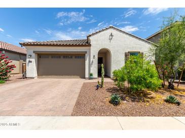 Charming single-story home featuring a two-car garage and a well-maintained, drought-resistant landscaped front yard at 18422 W Clinton St, Surprise, AZ 85388