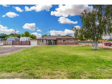 Charming single-story home with a well-manicured lawn, mature trees, and a welcoming facade under a bright sky at 25615 S Lemon Ave, Queen Creek, AZ 85142