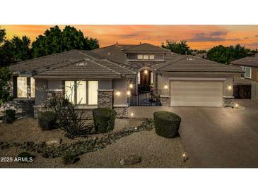 Beautiful single-story home features stone accents, desert landscaping, private courtyard, and three-car garage at 2565 N 141St Ln, Goodyear, AZ 85395