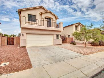 Charming two-story home features a balcony, two-car garage, and a driveway with desert landscaping at 3421 S 256Th Ave, Buckeye, AZ 85326