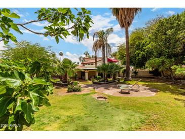 Lush backyard featuring mature trees, green grass, patio area with outdoor furniture, and an inviting atmosphere at 9430 S 47Th Pl, Phoenix, AZ 85044