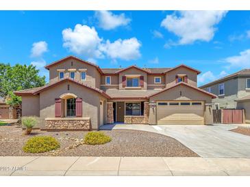 Two-story home featuring a three car garage, neutral stucco and stone accents with professionally landscaped front yard at 1526 E Glacier Pl, Chandler, AZ 85249