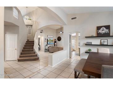 Open-concept living space with staircase, dining area, and living room, featuring tile floors and neutral tones at 20440 N 39Th Dr, Glendale, AZ 85308