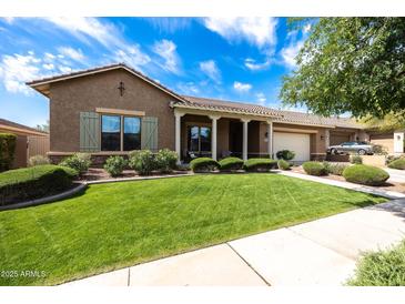 Charming single-story home with a well-manicured lawn and covered porch at 20585 W Garden St, Buckeye, AZ 85396