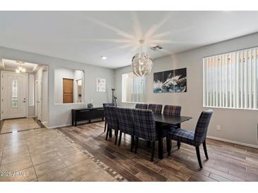 Bright dining room with a modern light fixture and plaid chairs at 2328 W Calle Marita --, Phoenix, AZ 85085