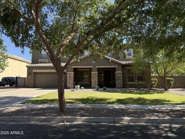 Charming two-story home featuring a well-manicured lawn, stone accents, and a spacious driveway at 2735 E Flower Ct, Gilbert, AZ 85298