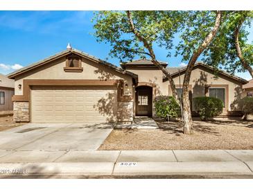 Charming single-story home featuring a two-car garage, neutral paint, stone accents and mature landscaping at 3029 N 83Rd Ln, Phoenix, AZ 85037