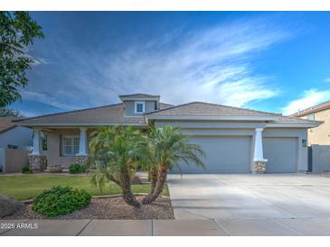 Inviting single-story home featuring a well-manicured lawn and a spacious two-car garage at 3736 E Cotton Ct, Gilbert, AZ 85234