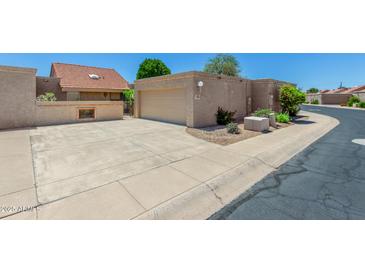 Home exterior features a two-car garage, large driveway, and low-maintenance landscaping at 4033 E Larkspur Dr, Phoenix, AZ 85032