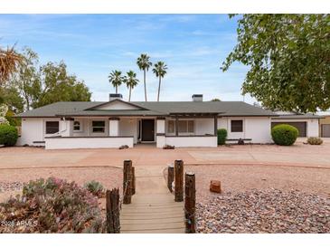 Charming ranch home with desert landscaping, mature palm trees, and unique walkway to front door at 4107 E Fairview Cir, Mesa, AZ 85206