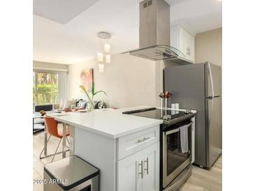 Bright kitchen features stainless steel appliances, white cabinets, and an island overlooking the living area at 4630 N 68Th St # 221, Scottsdale, AZ 85251