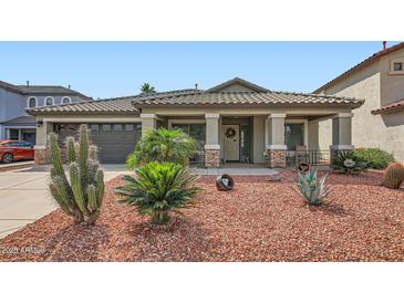 Charming single-story home featuring desert landscaping and a covered front porch at 5502 N Ormondo Way, Litchfield Park, AZ 85340