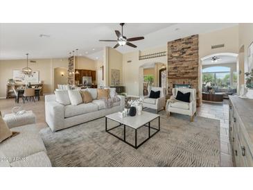 Spacious living room with a stone fireplace, neutral decor, and ample natural light at 616 E Lavitt Ln, Phoenix, AZ 85086