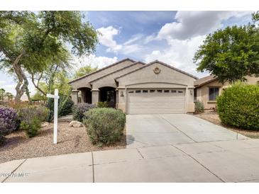 Charming single-story home with a well-manicured front yard and a two-car garage in a suburban setting at 6932 W Harwell Rd, Laveen, AZ 85339
