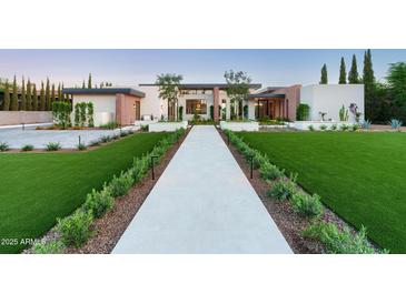 Striking modern home featuring a manicured lawn, geometric landscaping and an inviting stone walkway at 7341 E Sunnyside Dr, Scottsdale, AZ 85260