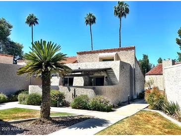 Well-maintained exterior of a home with a stucco wall, palm trees, and desert landscaping at 7409 N Via Camello Del Norte -- # 138, Scottsdale, AZ 85258