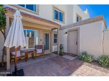 Charming outdoor patio with brick pavers, seating, and a shady umbrella for relaxing and entertaining at 7830 E Valley Vista Dr, Scottsdale, AZ 85250