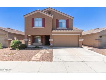 Charming two-story home features a two-car garage and well-maintained front yard with stone pathway at 10745 W Taft St, Phoenix, AZ 85037