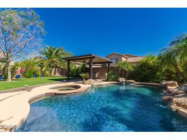 Resort-style backyard with sparkling pool, spa, covered patio, and lush landscaping, perfect for outdoor entertaining at 1453 E Elgin Pl, Chandler, AZ 85225