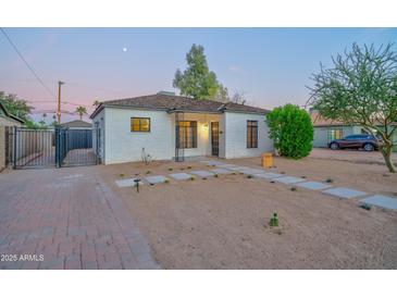 Charming painted brick home with desert landscaping and secure gated drive creates exceptional curb appeal at 2227 N 16Th Ave, Phoenix, AZ 85007