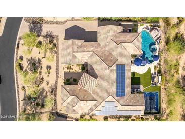 Stunning aerial view of a home with a tile roof, pool, basketball court, and solar panels at 37301 N 99Th St, Scottsdale, AZ 85262