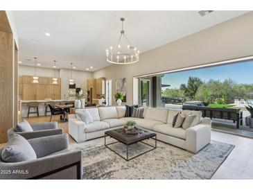 Bright living room featuring hardwood floors, modern lighting, and a large sectional sofa at 7032 E Balancing Rock Rd, Scottsdale, AZ 85266