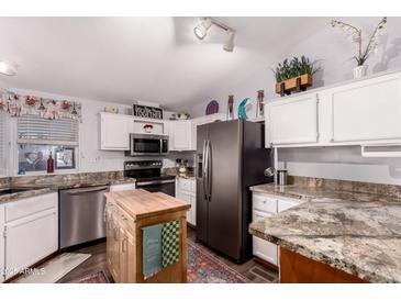 Modern kitchen featuring stainless steel appliances, white cabinets, and granite countertops at 8209 E 5Th Ave, Mesa, AZ 85208