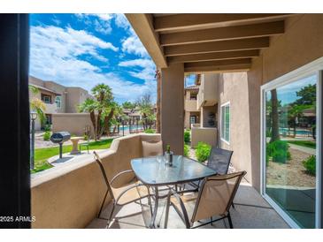 Enjoy outdoor living on this charming patio with a table set overlooking the community pool and lush landscaping at 9450 E Becker Ln # 1036, Scottsdale, AZ 85260