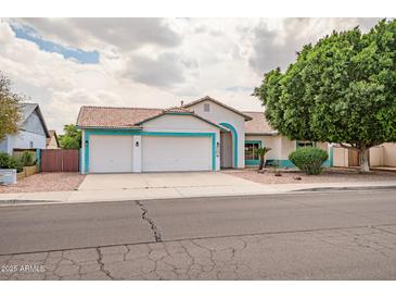 Charming single-story home boasts a three-car garage, desert landscaping and freshly painted trim at 10215 W Missouri Ave, Glendale, AZ 85307