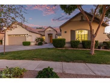 Charming single-story home featuring a well-maintained lawn and a two-car garage during a colorful sunset at 2045 E San Carlos Pl, Chandler, AZ 85249