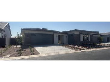 Beautiful single-story home with a modern design, well-maintained landscaping, and a two-car garage at 24000 S 218Th Pl, Queen Creek, AZ 85142