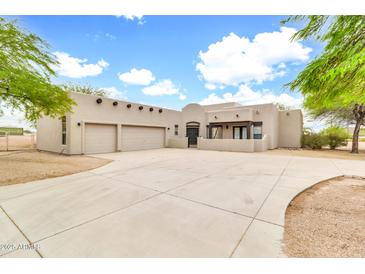 Charming stucco home featuring a spacious driveway, an attached two-car garage and decorative wood beam accents at 27347 N Gary Rd, San Tan Valley, AZ 85144