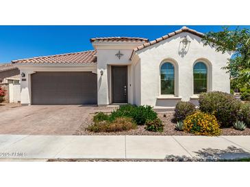 Charming single-story home with a brown tile roof, arched windows and a two car garage at 4051 S Galaxy Ln, Mesa, AZ 85212