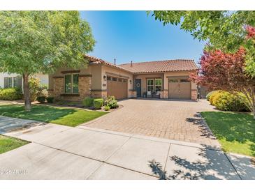 Beautiful single-story home featuring a paver driveway, a two-car garage, stone accents and mature landscaping at 4141 E Morrison Ranch Pkwy, Gilbert, AZ 85296