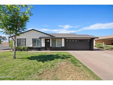 Charming single-story home with a well-maintained lawn, mature tree, and dark-colored garage at 540 W La Donna Dr, Tempe, AZ 85283