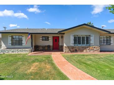 Charming single-story home featuring a bright red front door and meticulously maintained landscaping at 710 E Hayward Ave, Phoenix, AZ 85020