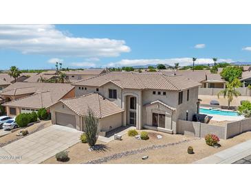 Stunning aerial view of a two-story home with a tile roof, a sparkling pool, and desert landscaping at 7472 E Black Rock Rd, Scottsdale, AZ 85255
