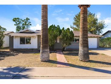 Charming single-story home with mature landscaping and a brick walkway at 8227 E Heatherbrae Dr, Scottsdale, AZ 85251