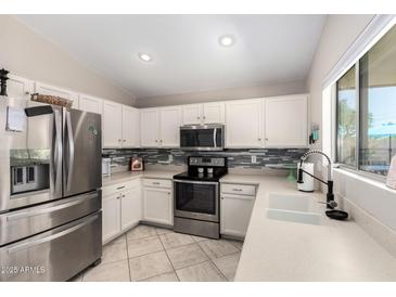 Well-lit kitchen features stainless steel appliances, white cabinets, and a modern sink at 13824 N 148Th Ln, Surprise, AZ 85379