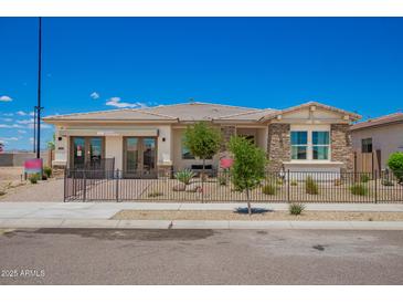 Beautiful single-story home with stone accents, desert landscaping, and a welcoming gated front yard at 14124 W Honeysuckle Dr, Surprise, AZ 85387