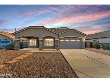 Charming single-story home with a well-manicured front yard and a covered entrance and a two car garage at 21759 E Estrella Rd, Queen Creek, AZ 85142