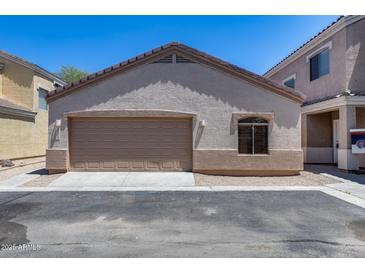 A tan stucco home featuring an attached garage with a brown garage door, and beige trim at 22225 N 29Th Dr, Phoenix, AZ 85027