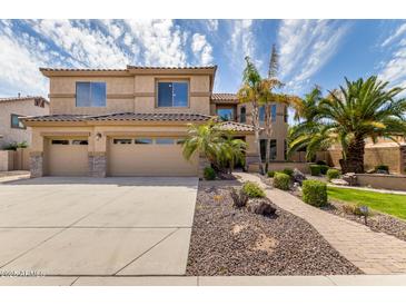 Charming two-story home showcasing a well-manicured front yard with lush landscaping and a three-car garage at 2302 S Canfield --, Mesa, AZ 85209