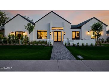 Striking modern home with a well-manicured lawn, walkway, and exterior lighting at 3301 E Elm St, Phoenix, AZ 85018