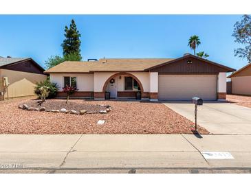 Charming single-story home featuring a decorative front yard with an arched entry and a two-car garage at 3415 E Anderson Dr, Phoenix, AZ 85032